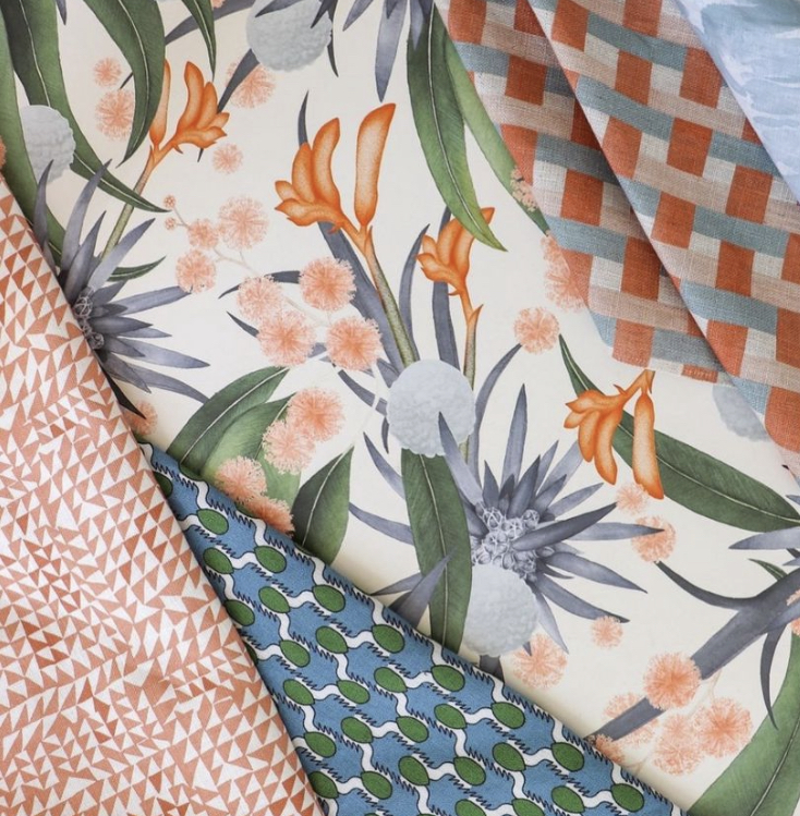 Layered fabric samples in botanical florals, orange gingham, and blue geometric prints