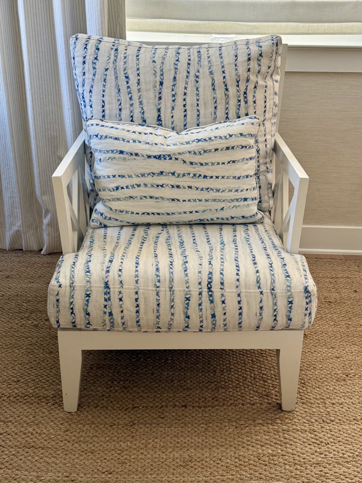 White X-back lounge chair upholstered in a blue watercolor stripe fabric