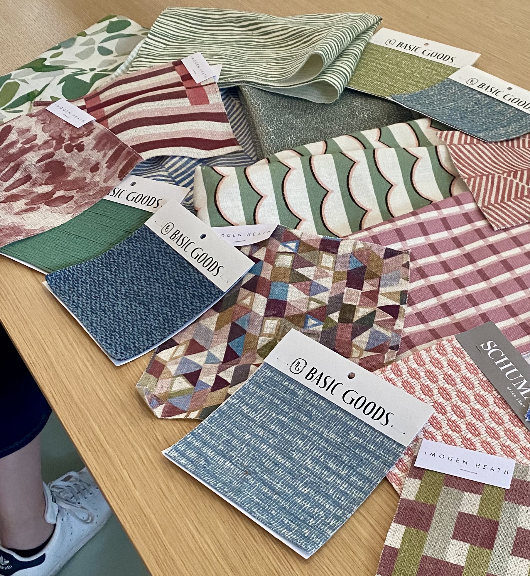 Basic Goods and Imogen Heath fabric swatches spread across an oak table